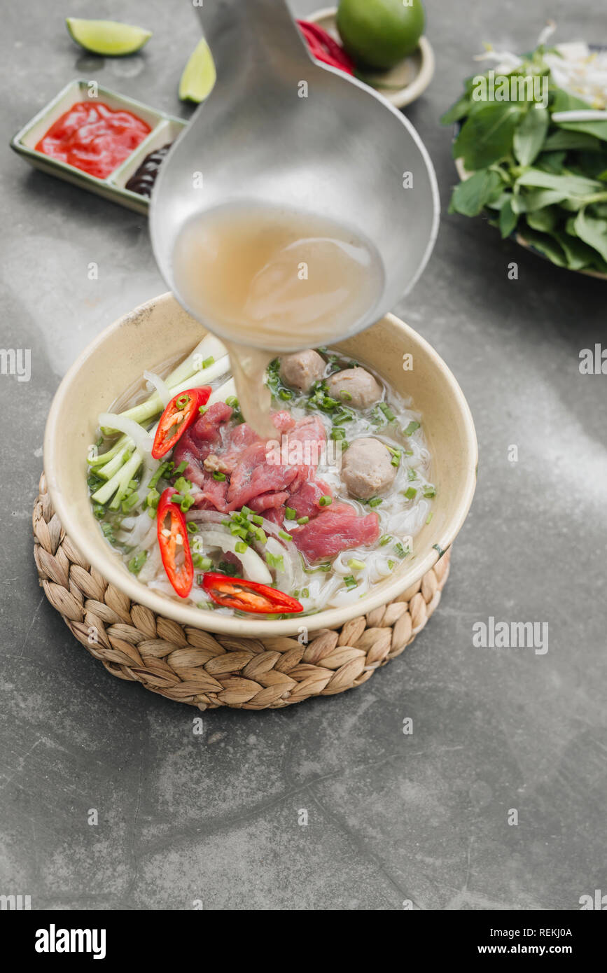 Pho Bo-vietnamesischen frischen Reis Nudelsuppe mit Rindfleisch, Kräuter und Chili. Lieferbar wird gegossen. Vietnams Nationalgericht. Stockfoto