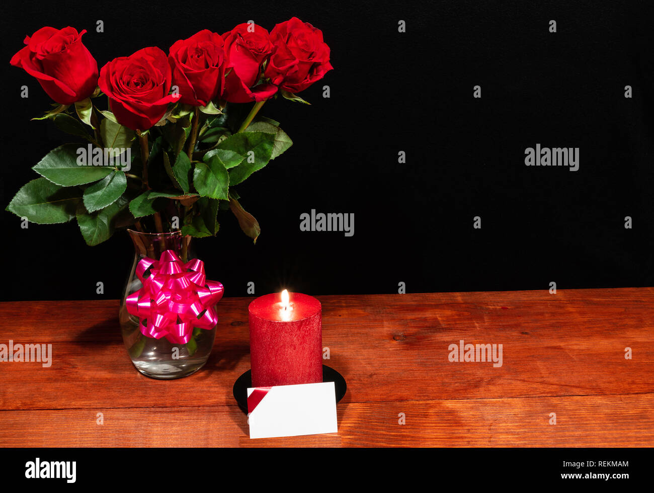 Schone Rote Rosen In Vase Mit Rosa Schleife Und Rote Kerze Mit Namensschild Auf Holztisch Auf Dunklem Hintergrund Valentinstag Muttertag Ostern Weihnachten Stockfotografie Alamy