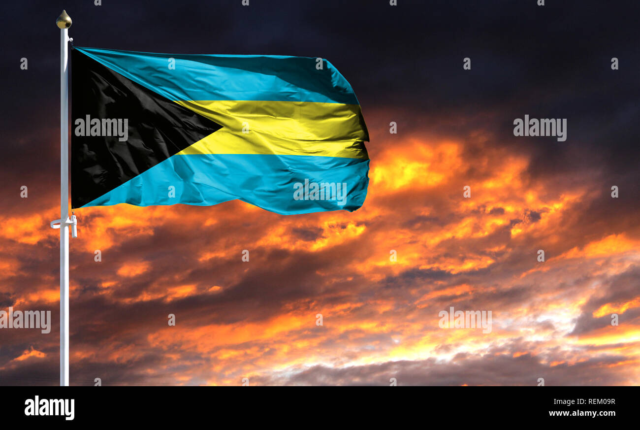 Flagge der Bahamas auf Fahnenmast im Wind flattern gegen einen farbenprächtigen Sonnenuntergang Himmel. Stockfoto