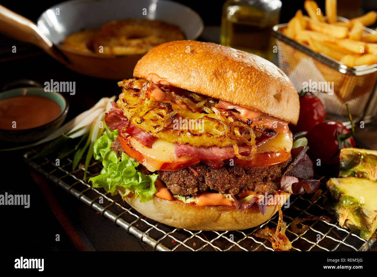 Hawaii Burger Mit Ananas Schinken Und Kase Uberbacken Mit Knusprig Gebratenen Zwiebeln Auf Einem Rack Von Zutaten Und Kartoffelchips Umgeben Stockfotografie Alamy