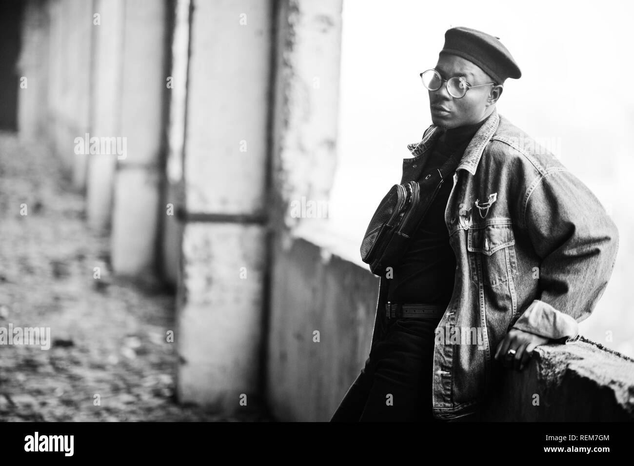 Afrikanische amerikanische Mann in Jeans Jacke, Baskenmütze und Brillen an verlassenen Ziegelei. Stockfoto