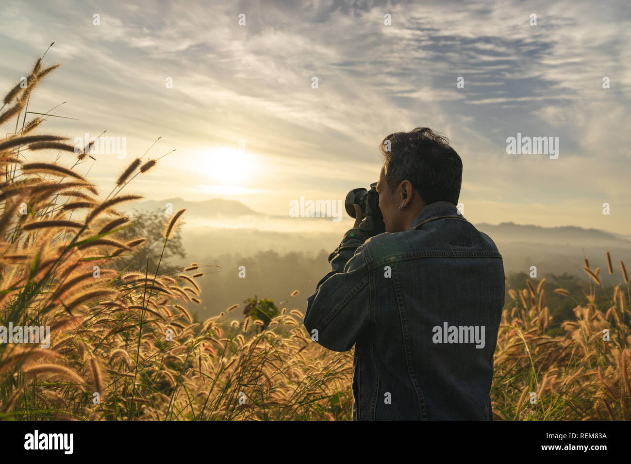 Halbe Länge ein kaukasischer Mann unter Foto von Foggy Mountain im Sonnenaufgang Zeit Stockfoto