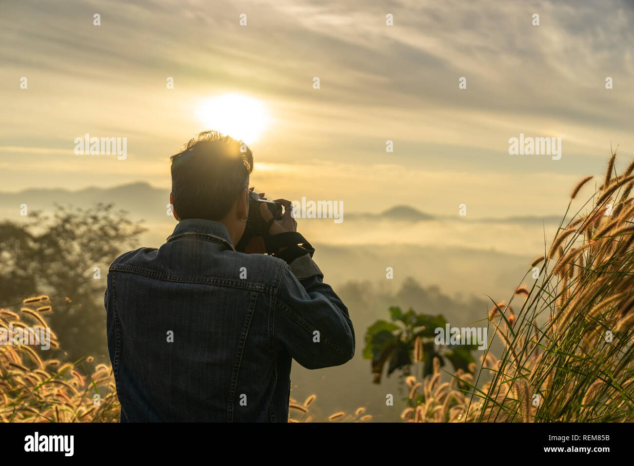 Halbe Länge ein kaukasischer Mann unter Foto von Foggy Mountain im Sonnenaufgang Zeit Stockfoto