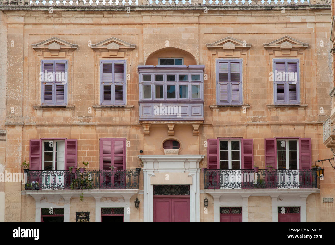 Casa Castelletti Galerie schöne Fassade mit rosa und lila Holzfensterrahmen und Fensterläden in Villegaignon St. in der antiken Stadt Mdina, Malta. Stockfoto