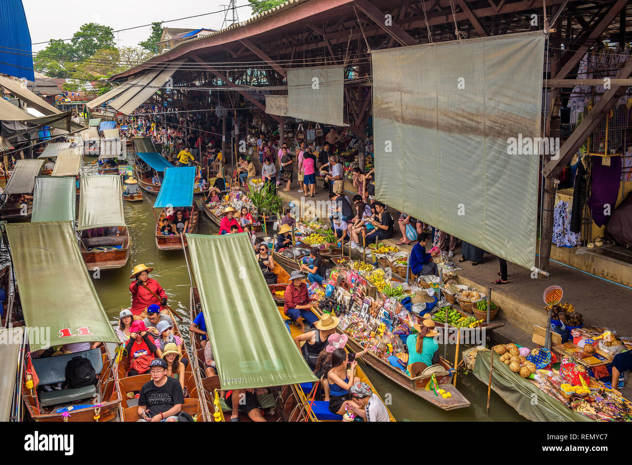 Touristen und Verkäufer in einem schwimmenden Markt in Thailand Stockfoto