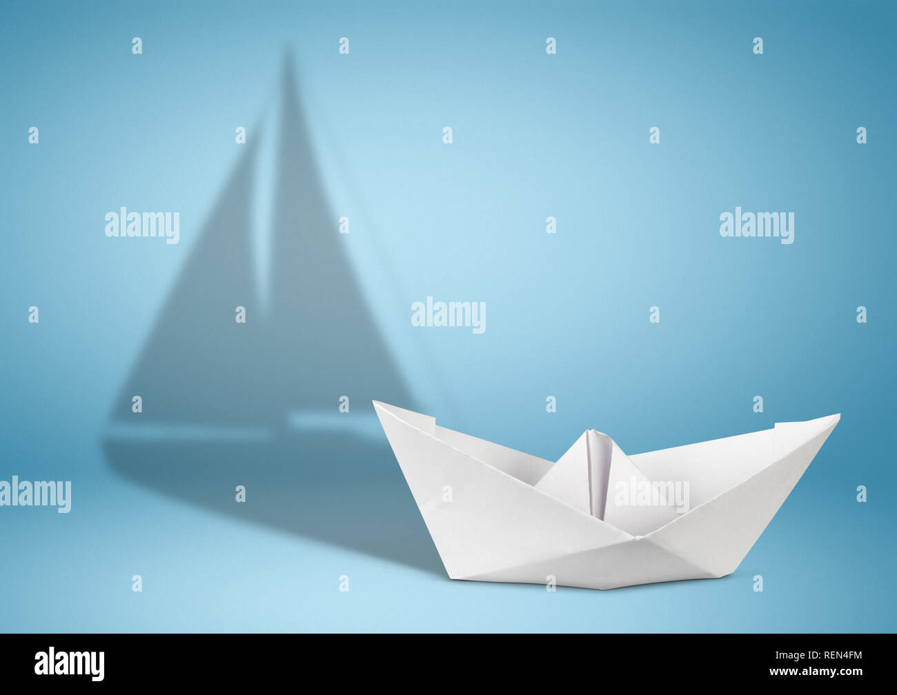Segelyacht Konzept, Papier Schiff mit Segelboot Schatten auf Blau Stockfoto