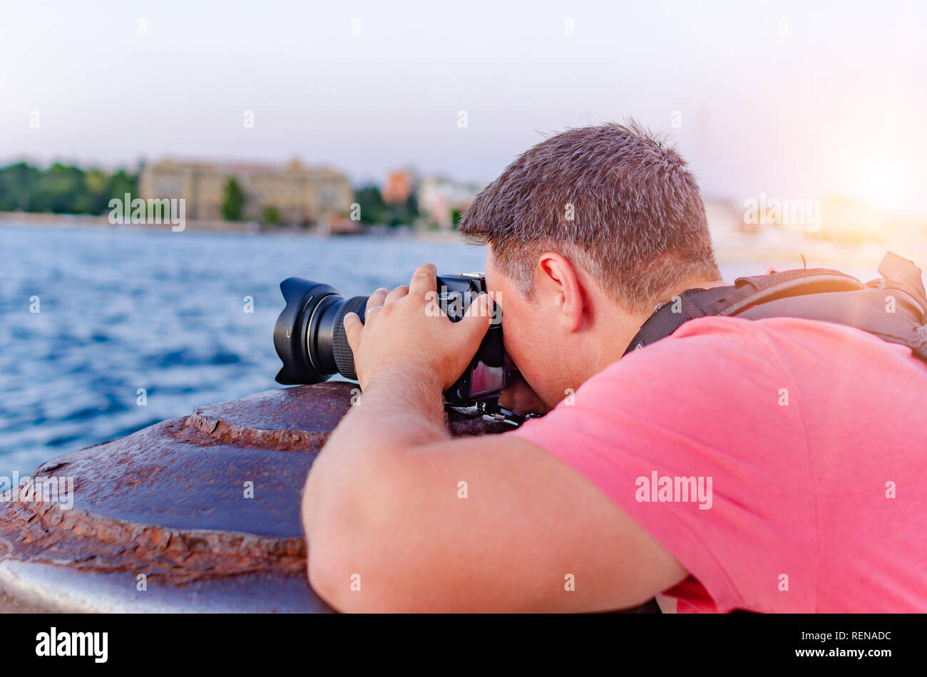 Der Mann mit der Kamera fotografieren den Sonnenuntergang an der Küste. Stockfoto