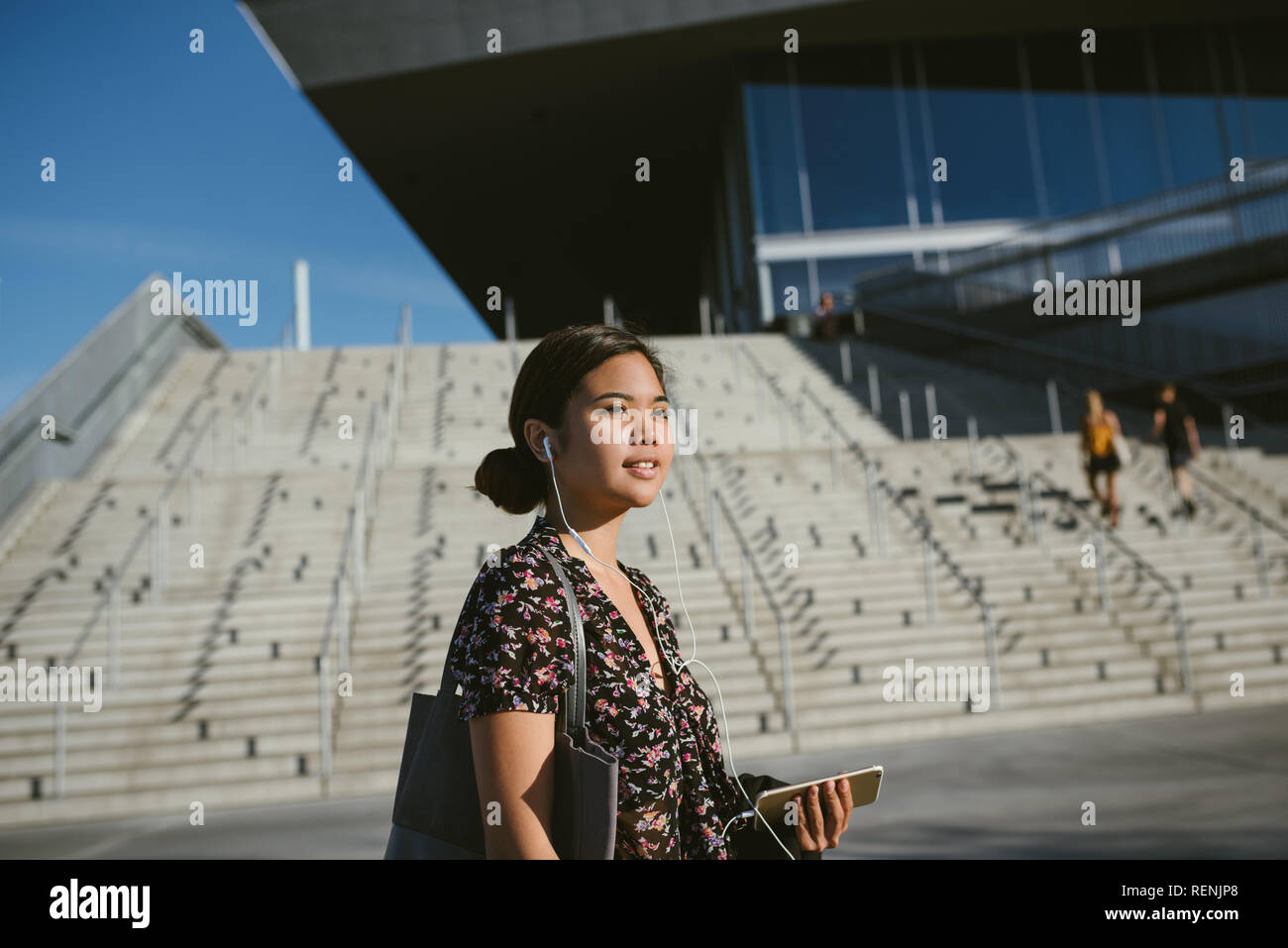 Lächelnd asiatische Studenten Wandern auf dem Campus Musik hören Stockfoto
