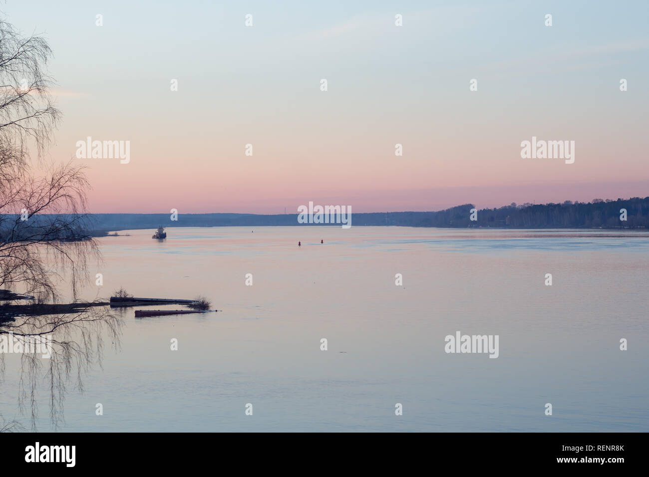 Friedlichen frühling landschaft bei Sonnenuntergang auf dem Fluss mit Schiff und Wald im Hintergrund Stockfoto