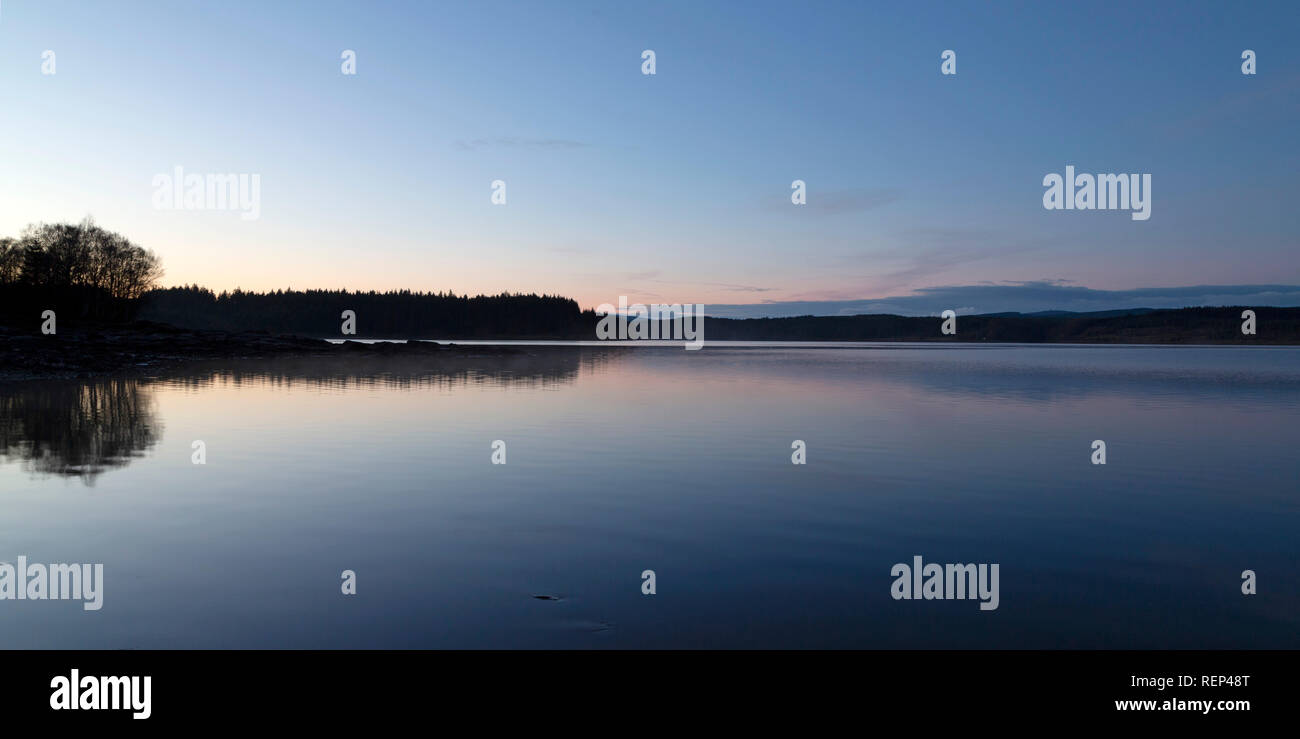 Der ruhigen Oberfläche des Kielder Water bei Dämmerung in Northumberland, England. Der See ist Teil der Wasser- und Kielder Forest Park und innerhalb von Northumbe Stockfoto