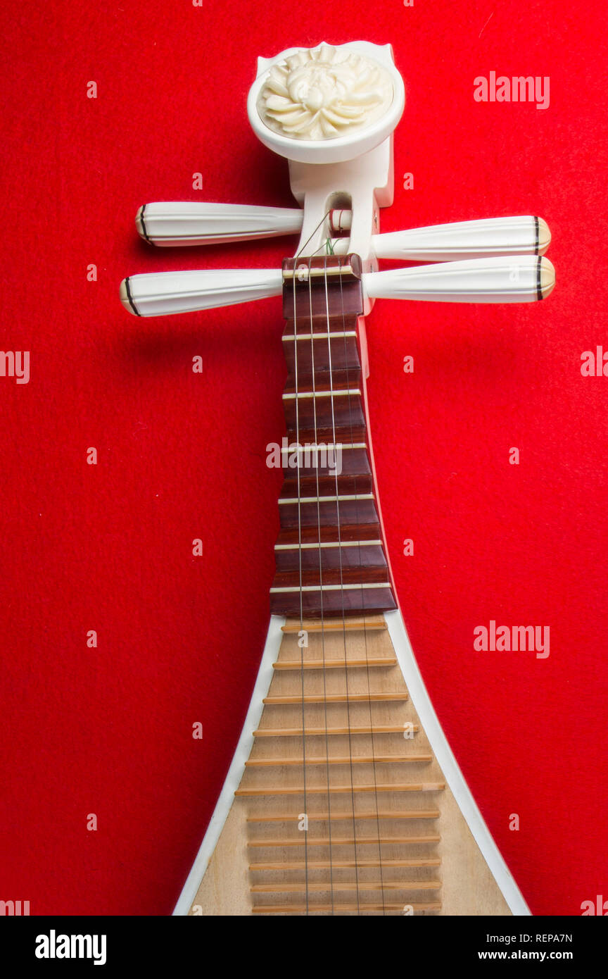 Pipa chinesische Gitarren, 4-saitige Laute mit 30 Bünden und Birnenförmigen Körper, auf rotem Hintergrund Stockfoto