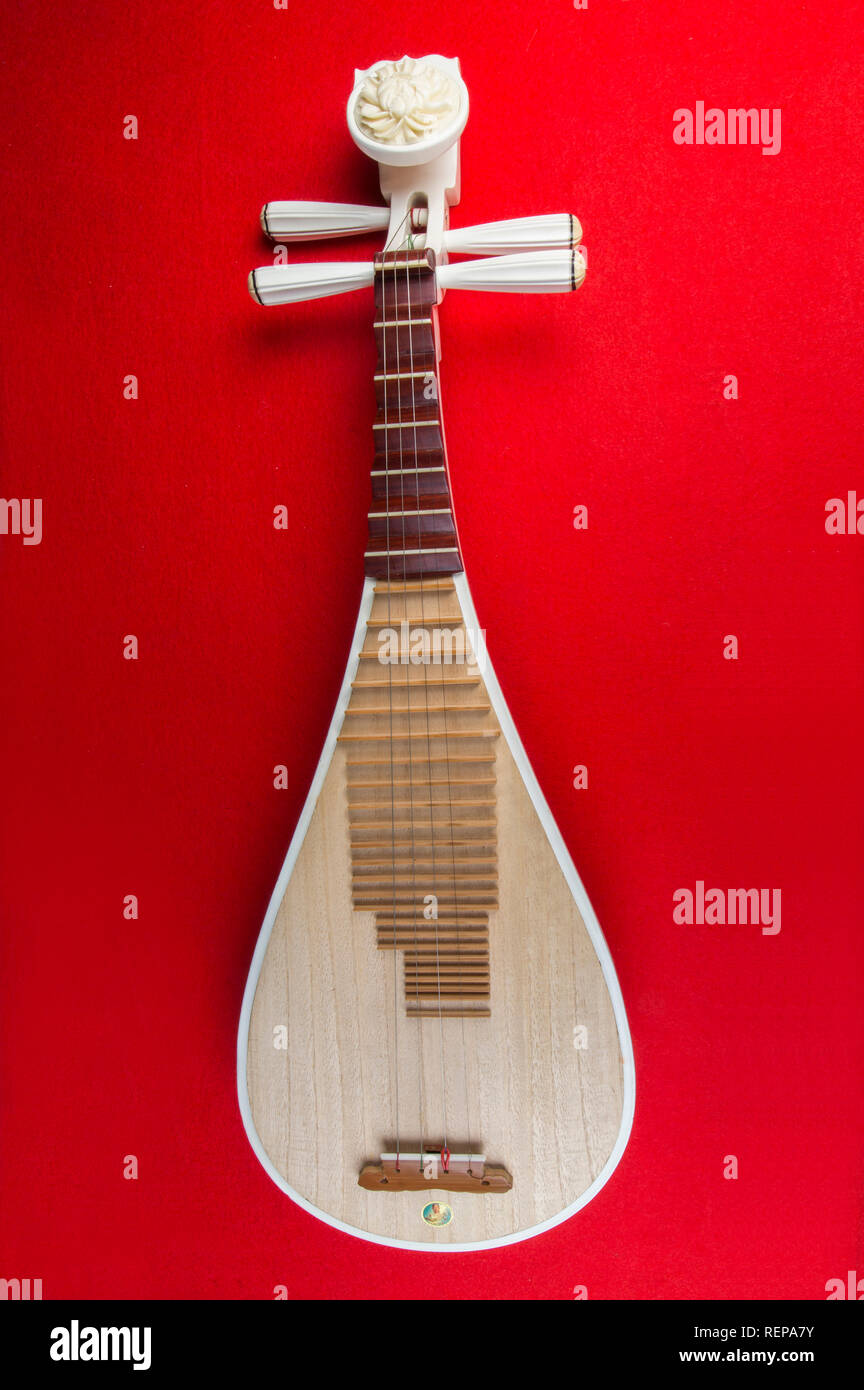 Pipa chinesische Gitarren, 4-saitige Laute mit 30 Bünden und Birnenförmigen Körper, auf rotem Hintergrund Stockfoto