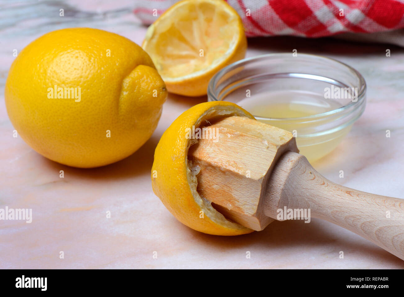 In Zitronensaft Zitrone, Schale und Zitronenpresse mit ausgepresster Zitrone Stockfoto