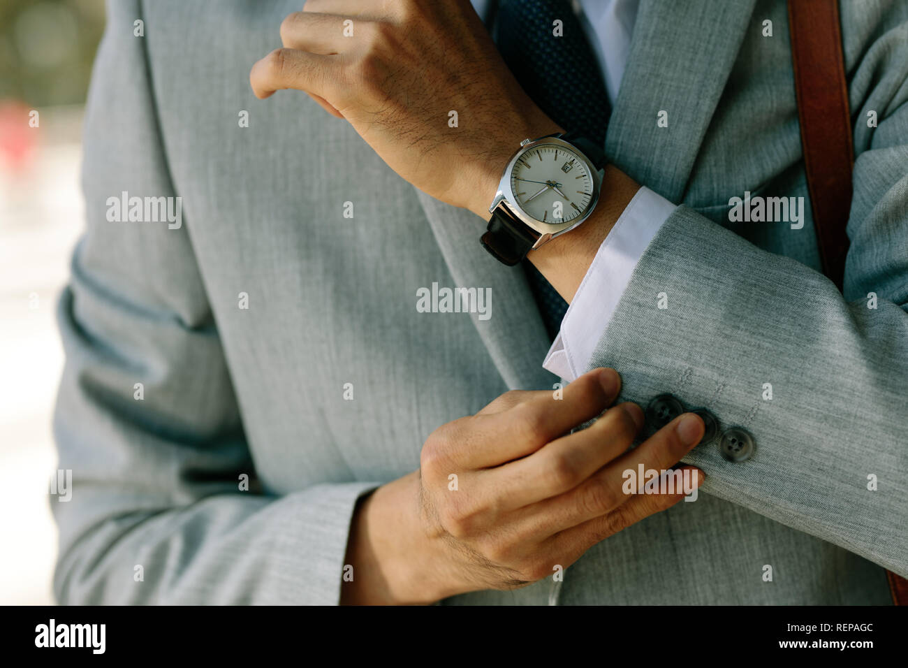 Geschäftsmann, der seine Handschellen zuknöpft. Kurze Aufnahme von Business-Profis, die seine Blazer-Ärmel aufknöpfen. Stockfoto