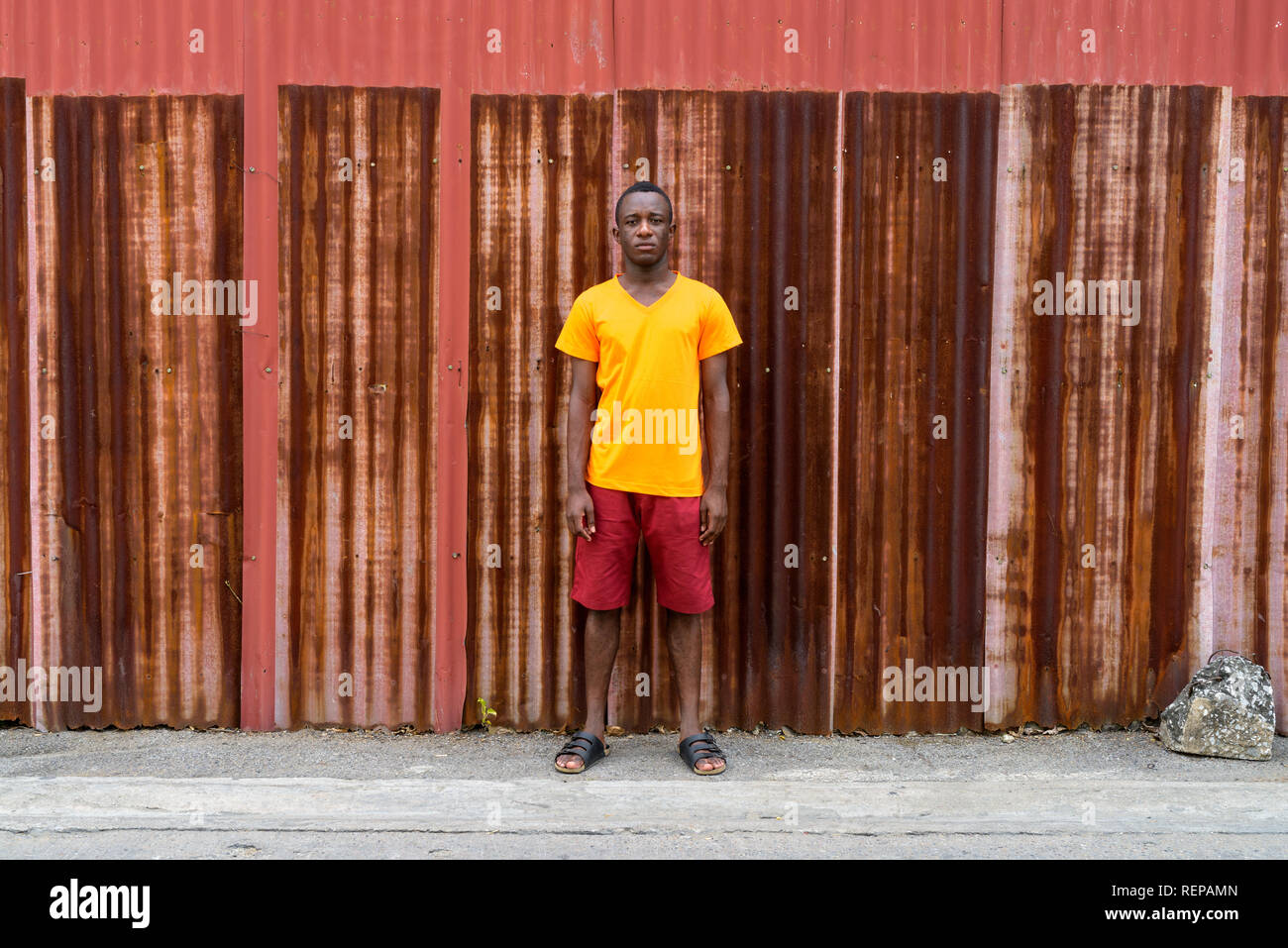 Jungen schwarzen afrikanischen Mann gegen die alten rostigen Blech Wand Stockfoto