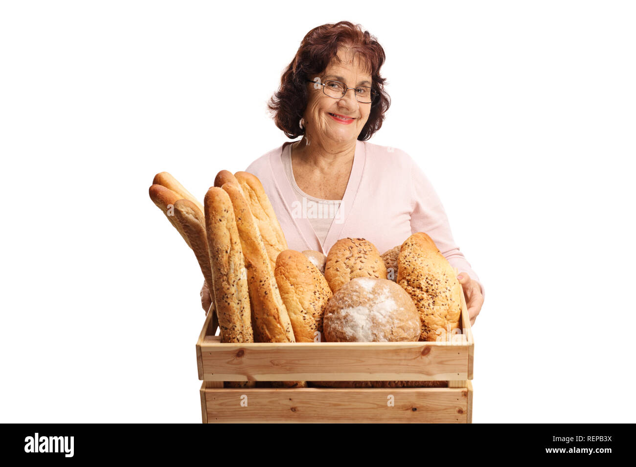 Ältere Frau mit einer Kiste voll von verschiedenen Arten von Brot auf weißem Hintergrund Stockfoto