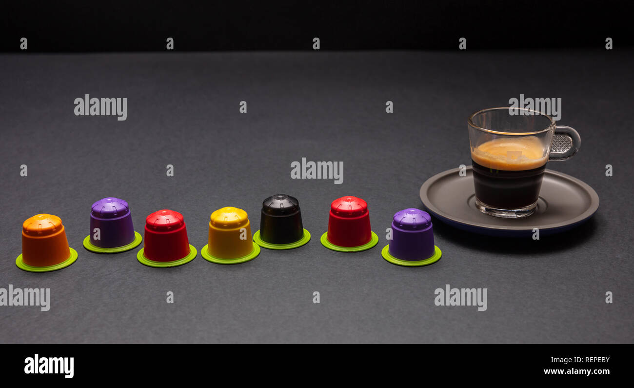 Espresso Tasse und comostable Kapseln, Kaffeepads, auf Schwarz Farbe Hintergrund, Vorderansicht Stockfoto