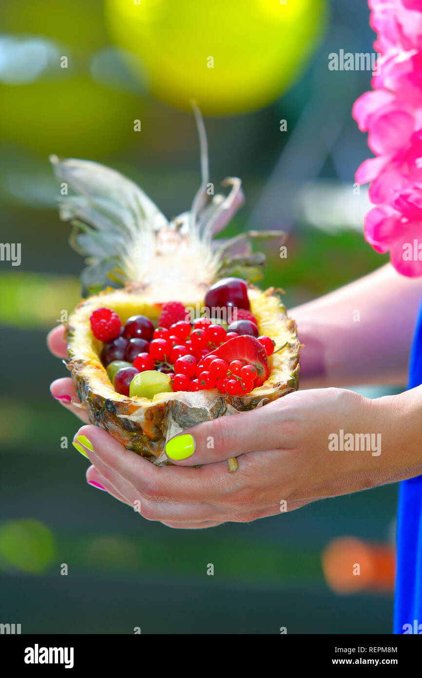 Obst Salat in einer Ananas in der Hand von Frauen gehalten Stockfoto