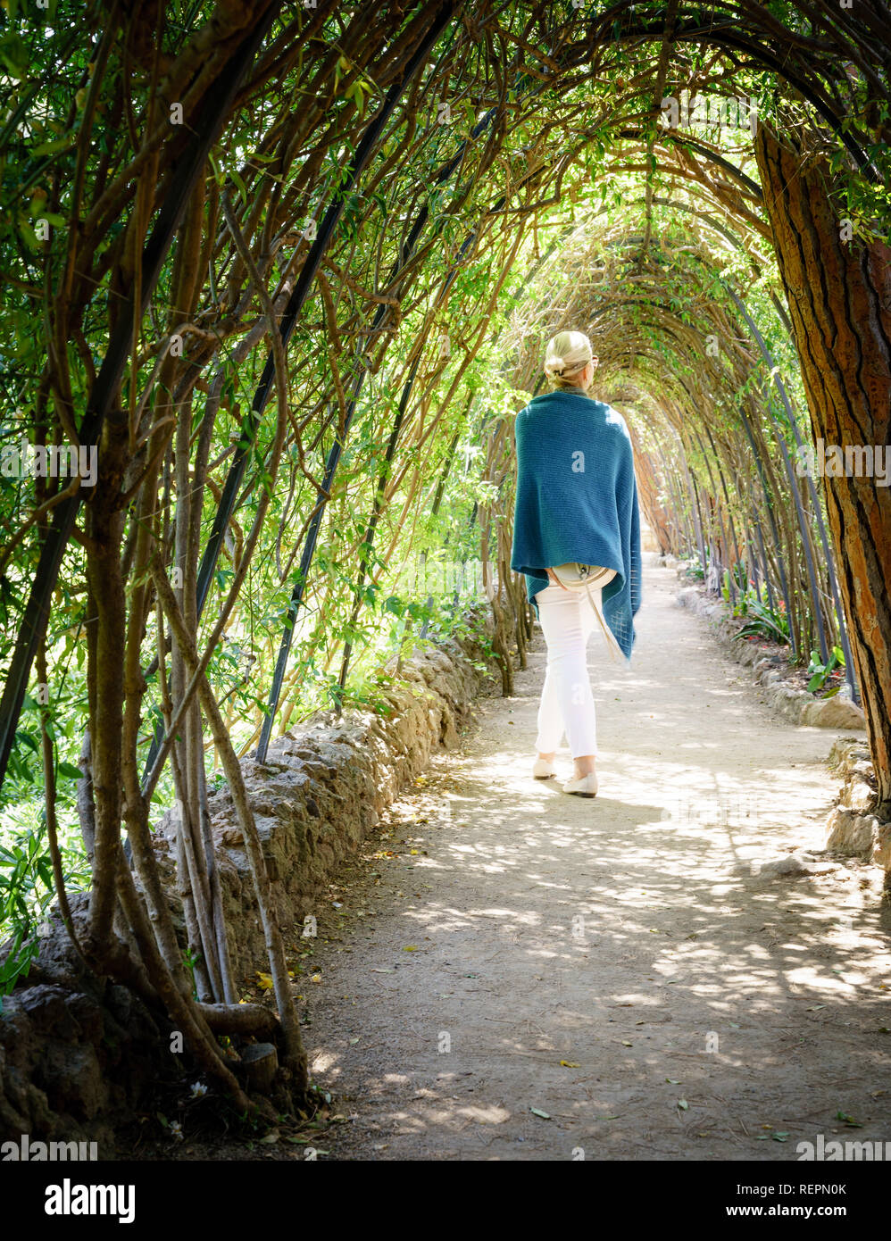 Frau entlang Schattierungen Gasse in einem Park in Barcelona, Spanien Stockfoto