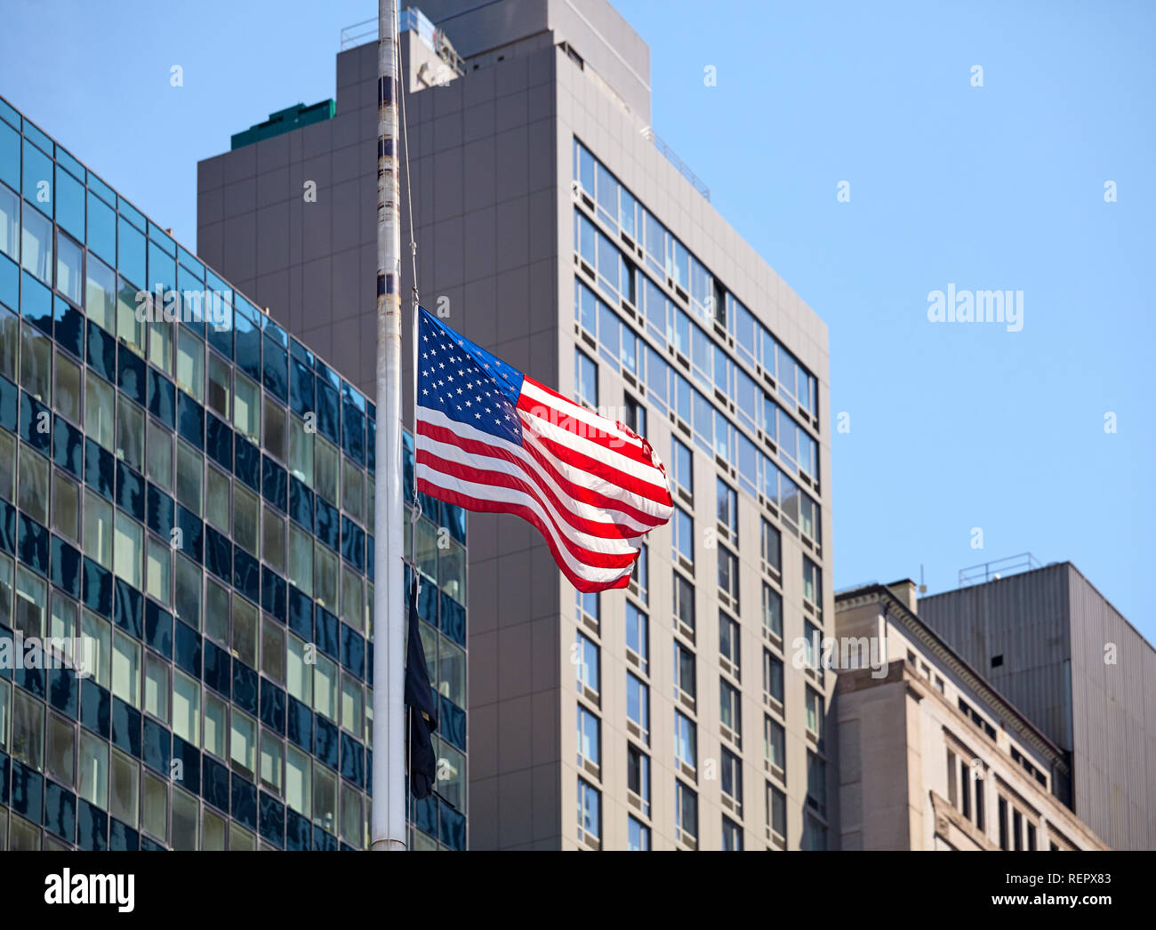 Fliegen amerikanische Flagge mit modernen Gebäude im Hintergrund, selektiver Fokus, New York, USA. Stockfoto