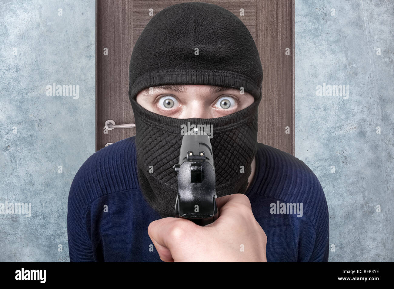 Gewehr auf die Kriminellen in Balaclava, das Bild auf dem Hintergrund der Tür, das Konzept der Fang der Dieb Stockfoto