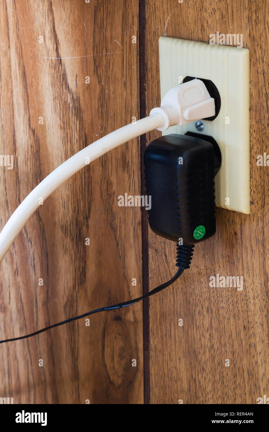 In der Nähe von computer Netzkabel und Transformator angeschlossen an eine elektrische Steckdose innerhalb eines Hauses Stockfoto