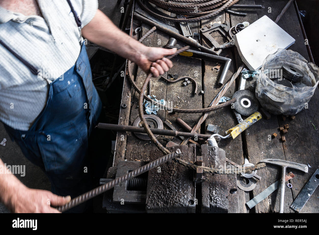 Schmied, schmiedeeisernen mit industriellen Bender Maschine für Metall biegen. Stockfoto