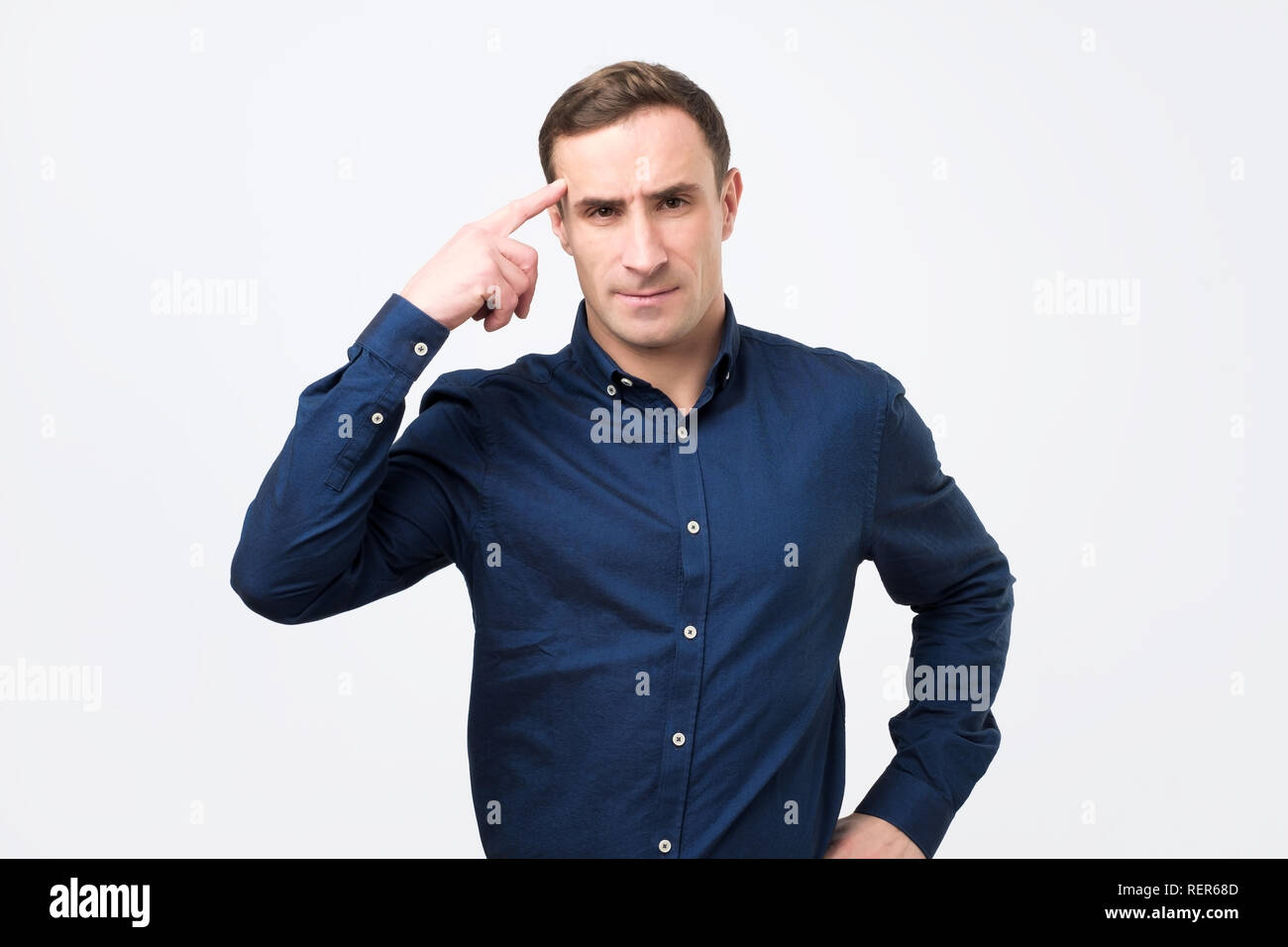 Wütend italienischen Mann im blauen Hemd zu seinem Tempel über die Frage streiten zeigt. Stockfoto