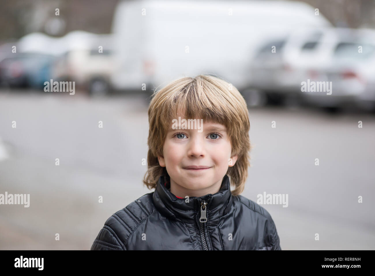 Porträt eines lächelnden Jungen mit einem unscharfen Hintergrund, kaltes Wetter Stockfoto