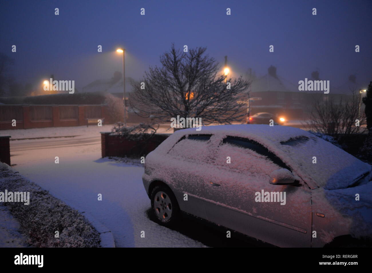 Auto auf einer Fahrstraße in Schnee und Eis bedeckt am frühen Morgen nach einem eiskalten Winternacht, UK geparkt Stockfoto