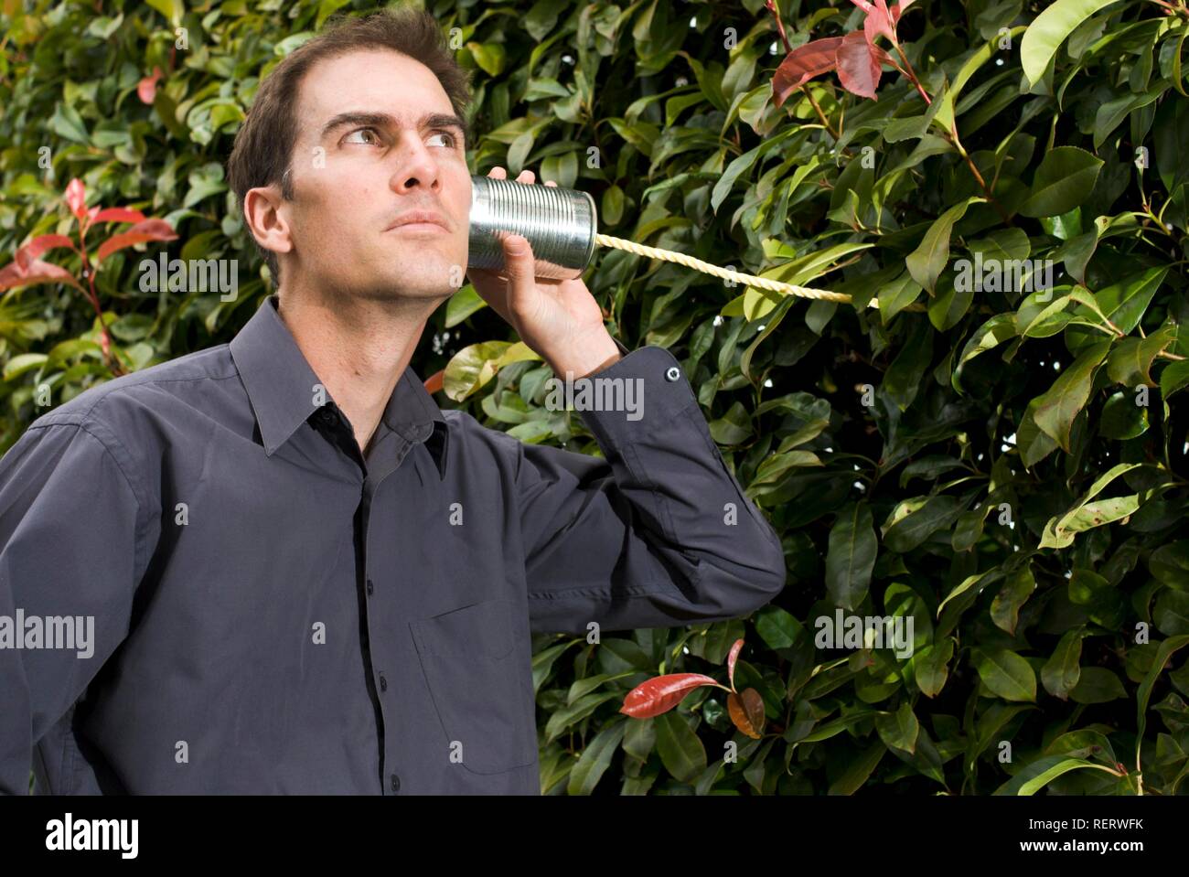 Junger Mann hören auf die Natur und die grüne, symbolisch für eine umweltbewusste und nachhaltige Zukunft, Grün Stockfoto