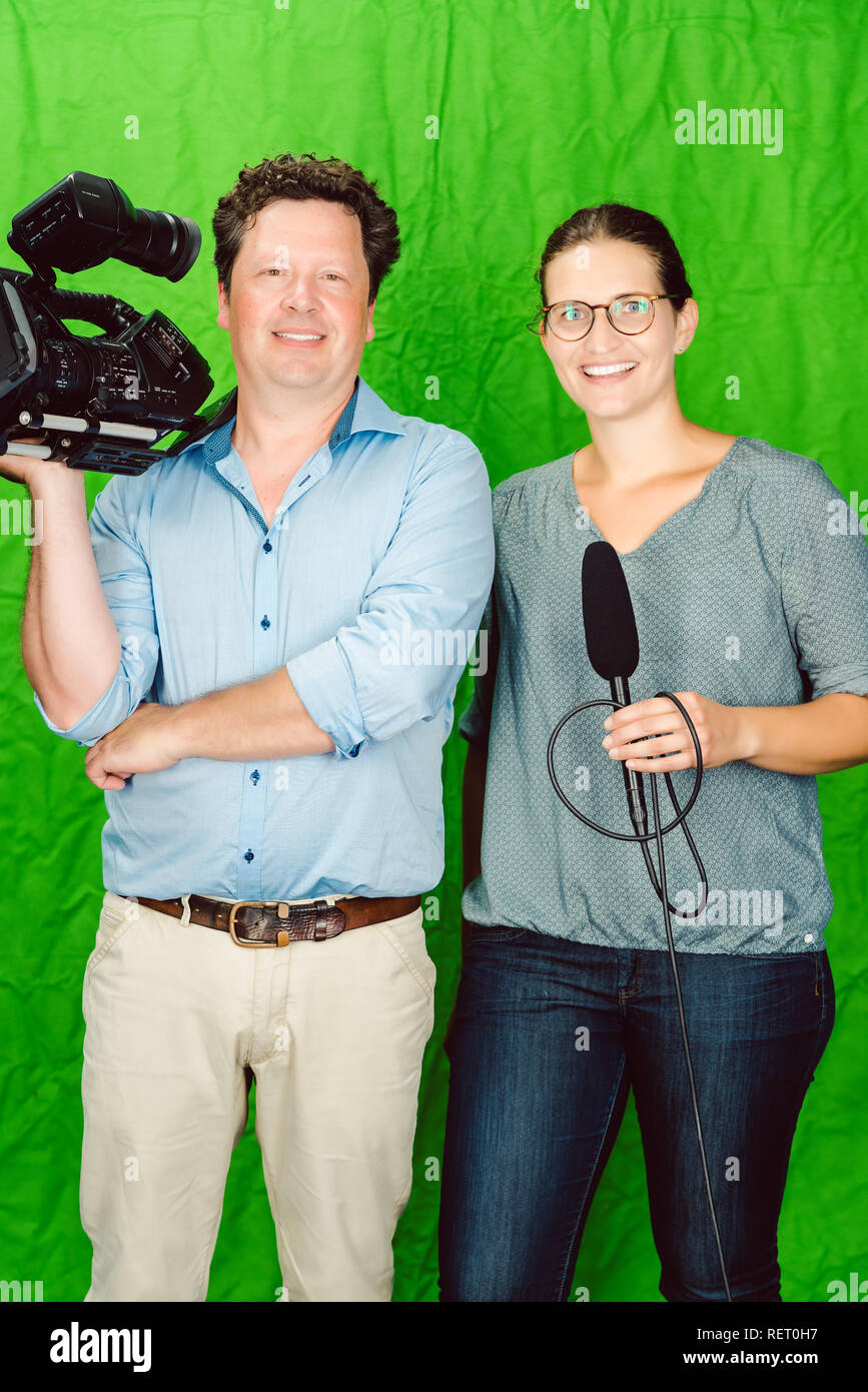 Crew der Reporter und Kameramann posiert im Studio Stockfoto