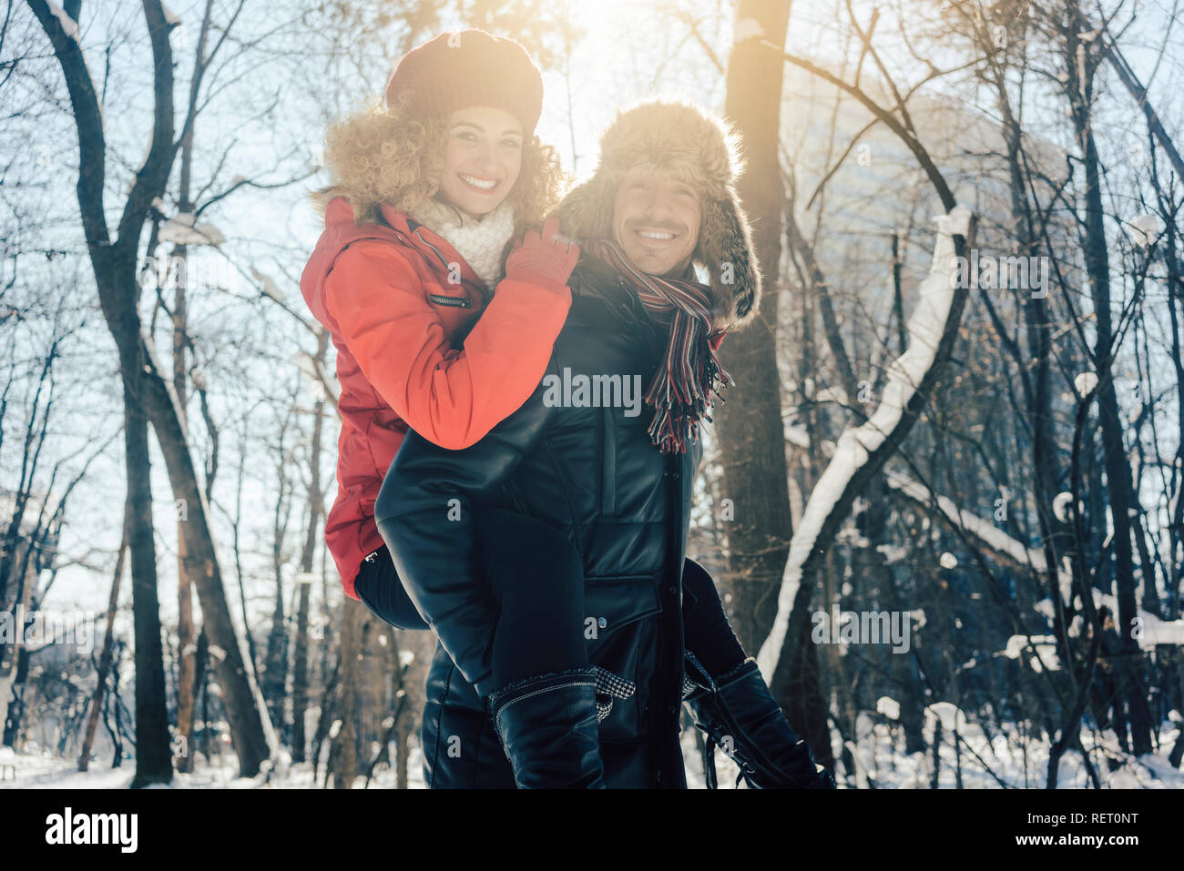 Mann, der seine Frau huckepack an einem Wintertag Stockfoto