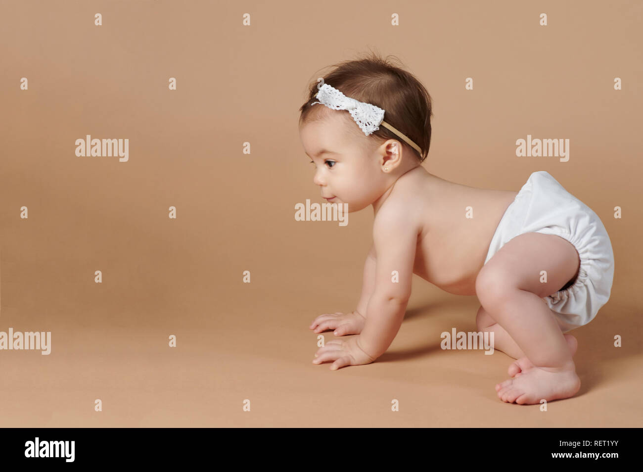 Kleines Baby kriechen auf browncolor studio Hintergrund Stockfoto