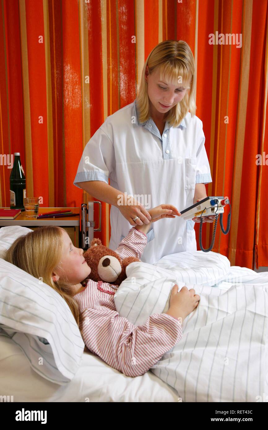 Krankenschwester, die Pulsfrequenz eines jungen Patienten, 7 Jahre, im Krankenhaus Stockfoto