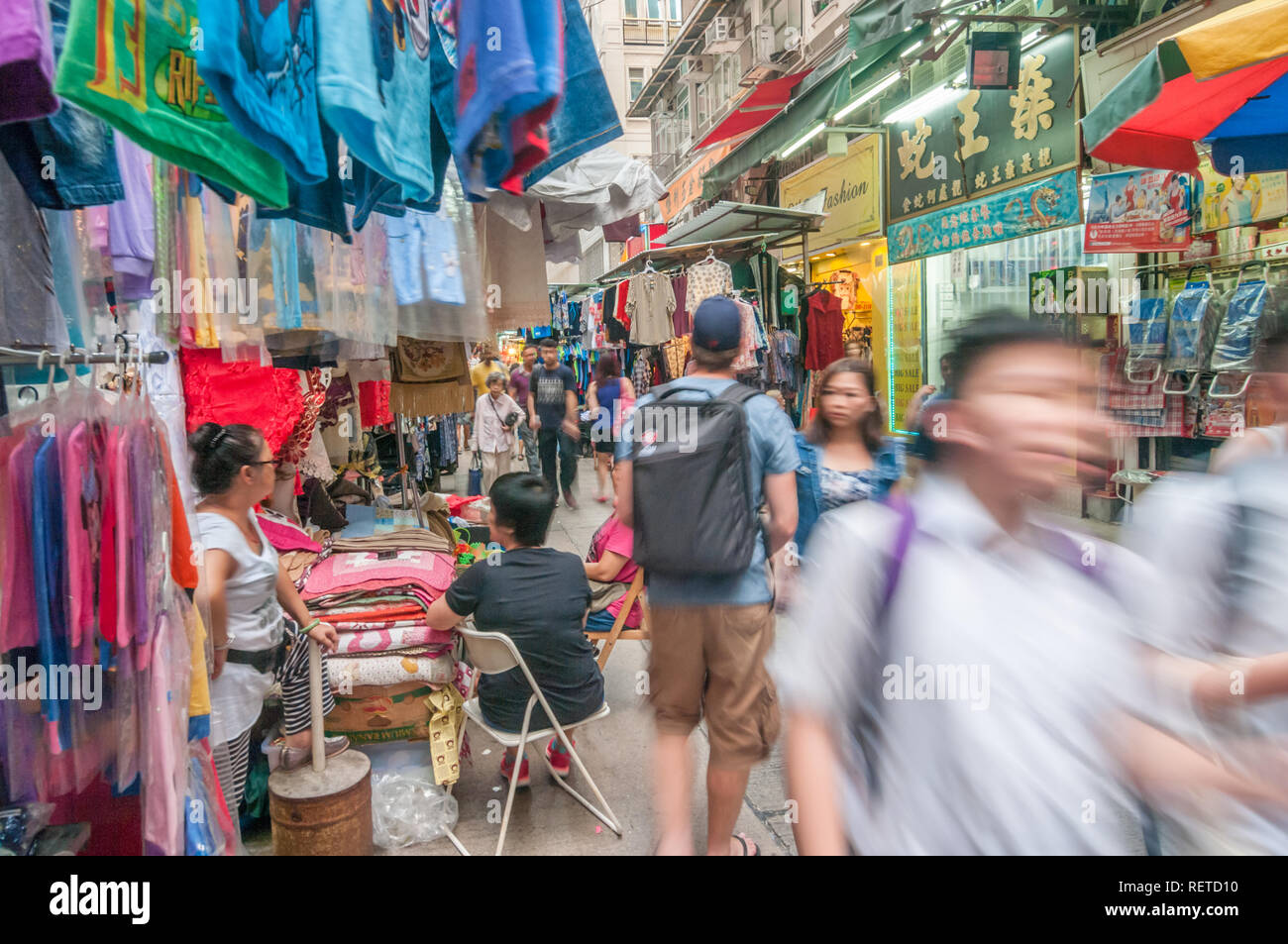 Die Menschen in der überfüllten Markt im Freien mit lebendigen Farben wie zahlreiche Händler, die eine Vielzahl von Waren und Dienstleistungen in Hongkong, China. Stockfoto