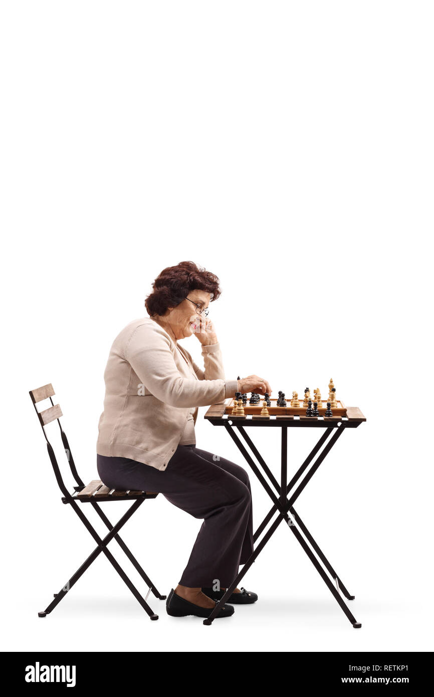 Volle Länge Profil Schuß einer älteren Frau mit einem Schachbrett an einem Tisch in der Chess Abbildung und Denken auf weißem Hintergrund suchen Stockfoto