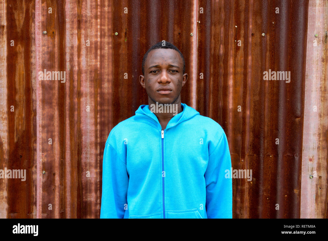 Junge schwarze afrikanische Menschen gegen die alten rostigen Blech Wand Stockfoto