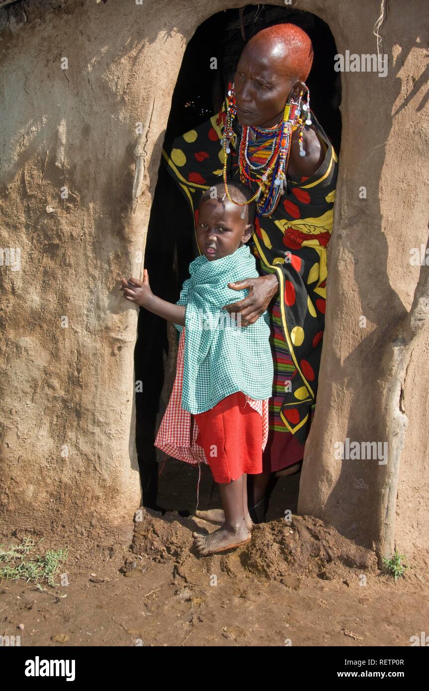 Masai Mutter und ihr Kind am Eingang zu einer Hütte, Masai Mara, Kenia, Ostafrika Stockfoto