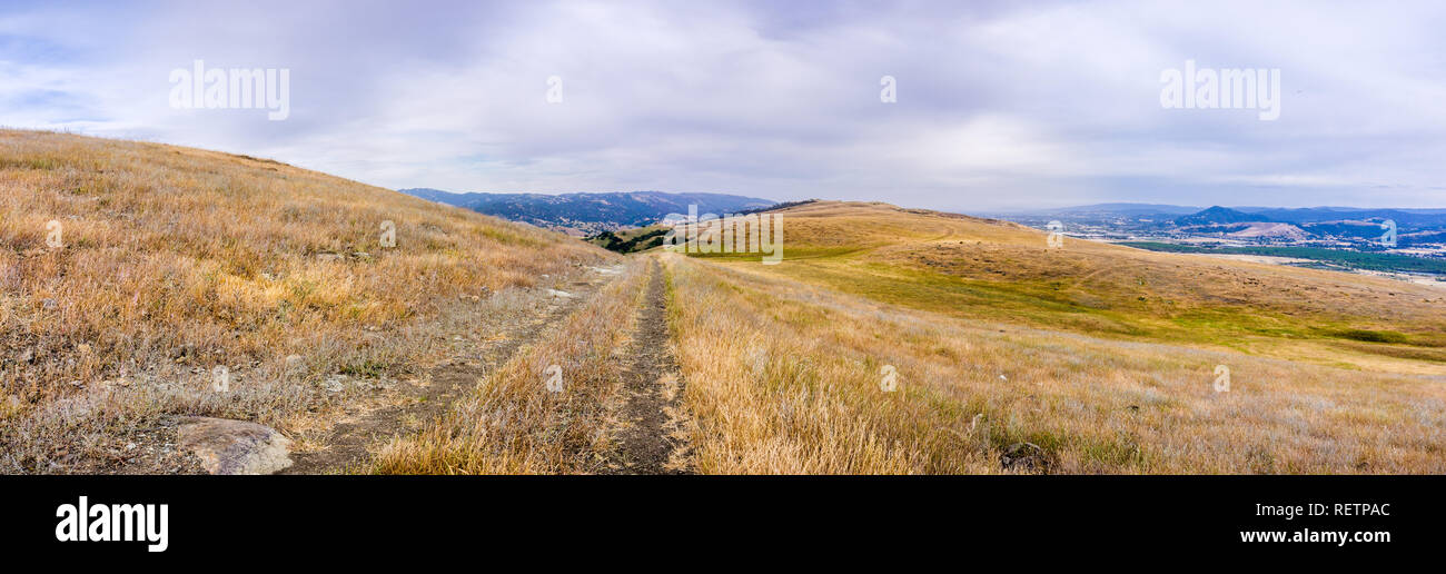 Wanderweg zwischen Hügeln und Tälern in trockenem Gras bedeckt, South San Francisco Bay Area, San Jose, Kalifornien Stockfoto