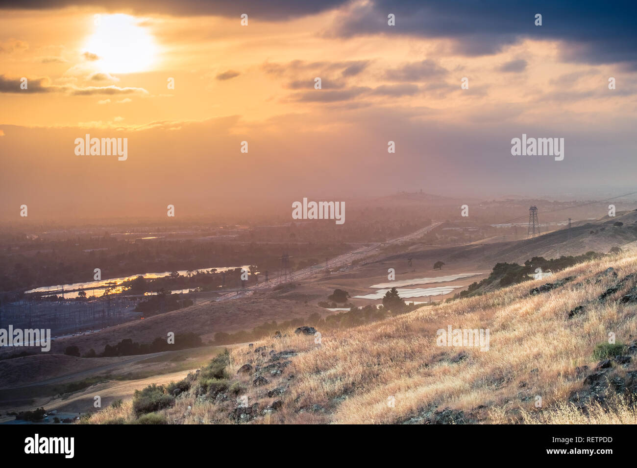 Gefilterte Licht über die grasbewachsenen Hügeln von South San Francisco Bay Area, San Jose; Bayshore Freeway im Tal sichtbar, Kalifornien Stockfoto