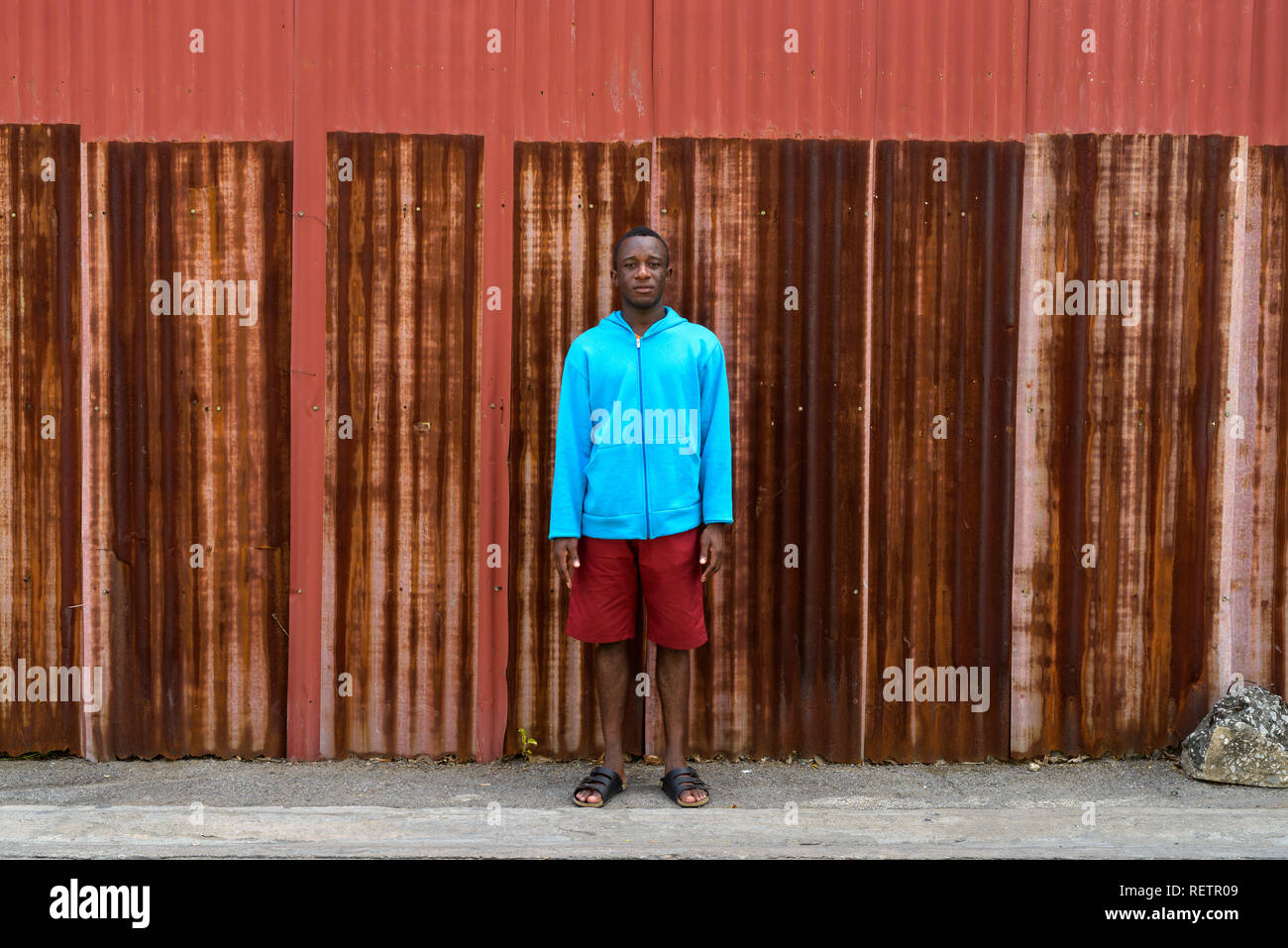 Jungen schwarzen afrikanischen Mann gegen die alten rostigen Blech Wand Stockfoto