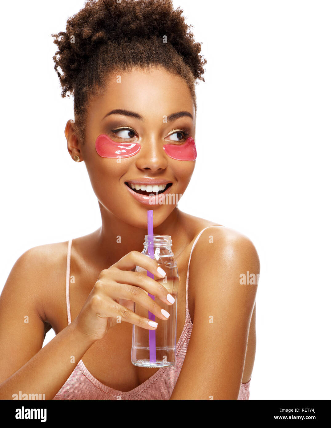 Schöne Mädchen mit rosa Auge Flecken auf ihrem Gesicht und hält eine Flasche Wasser. Foto der jungen afrikanischen amerikanischen Mädchen auf weißem Hintergrund. Y Stockfoto