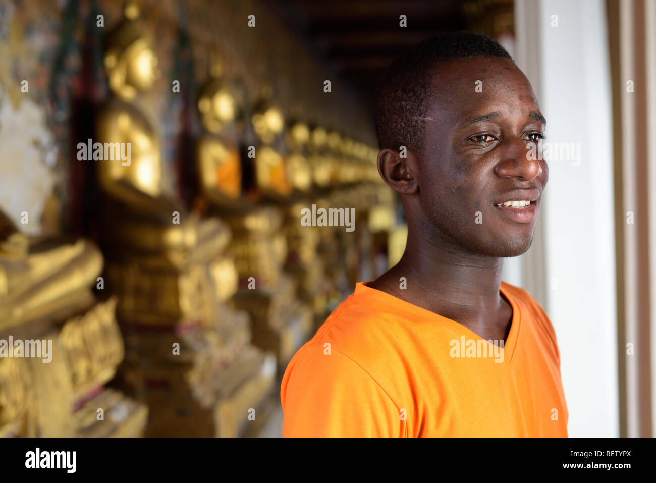 Junge glücklich afrikanischen Mann an buddhistischen Tempel lächelnd Stockfoto