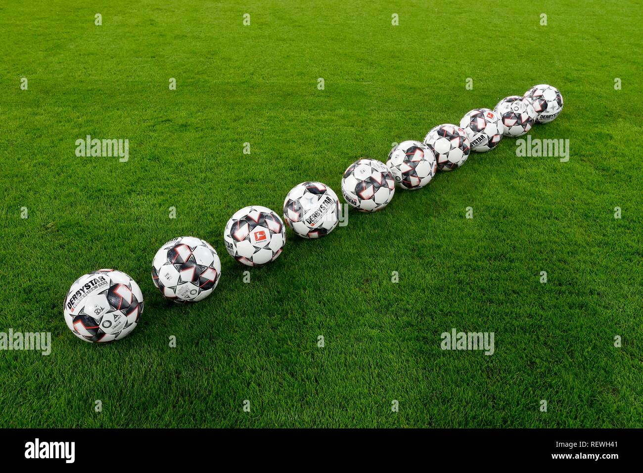 10 Fußbälle adidas Derbystar in einer Reihe auf Gras, Allianz Arena, München, Bayern, Deutschland Stockfoto