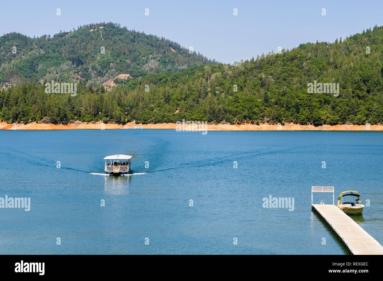 Shasta Lake, McCloud River Arm Landschaft an einem sonnigen Sommertag mit Schiff nähert sich der Küste, Nordkalifornien Stockfoto