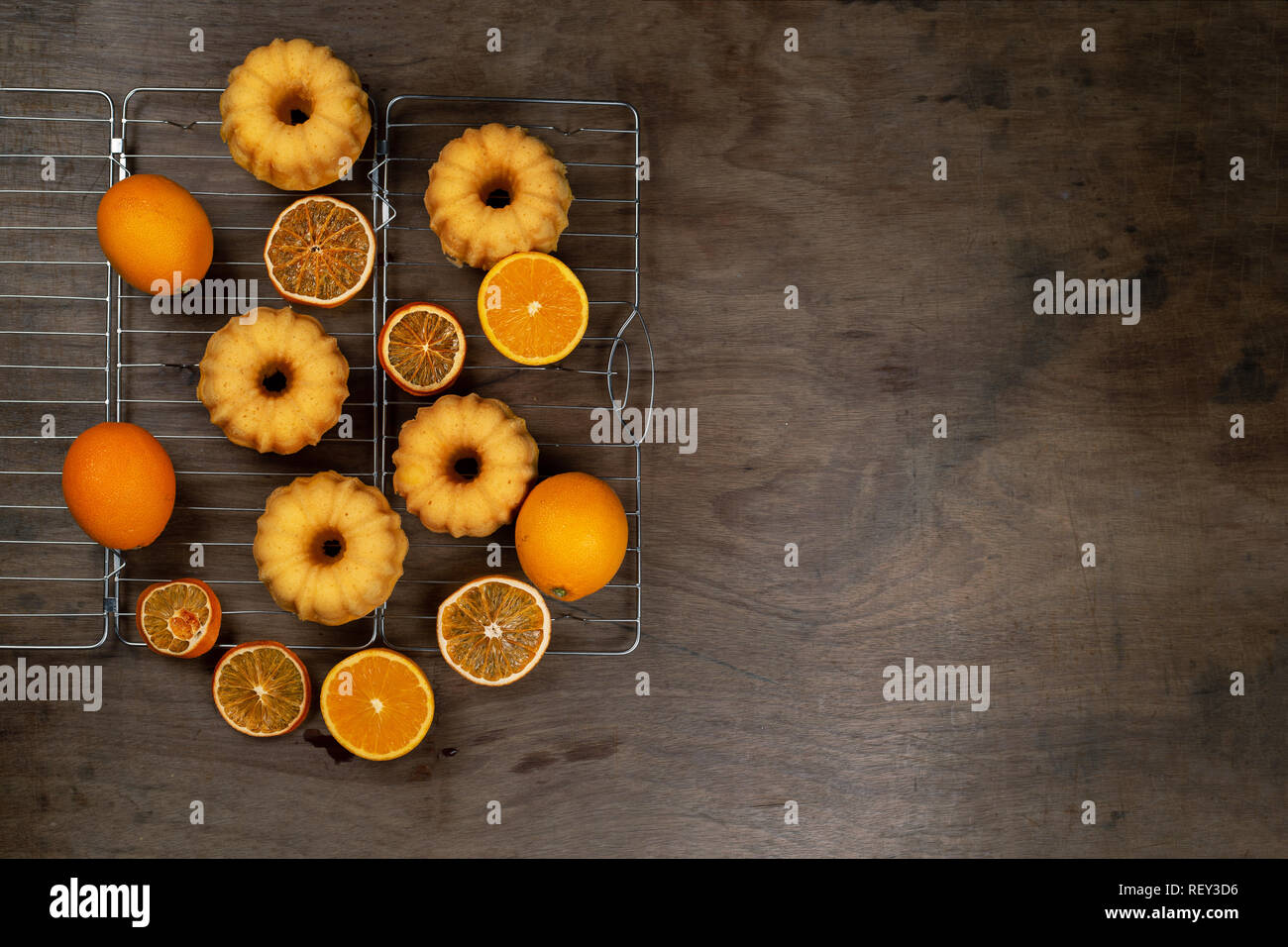 Kleine orange bundt Kuchen mit frischen und trockenen Orangen auf Kühlung ruck, Ansicht von oben, flach Stockfoto