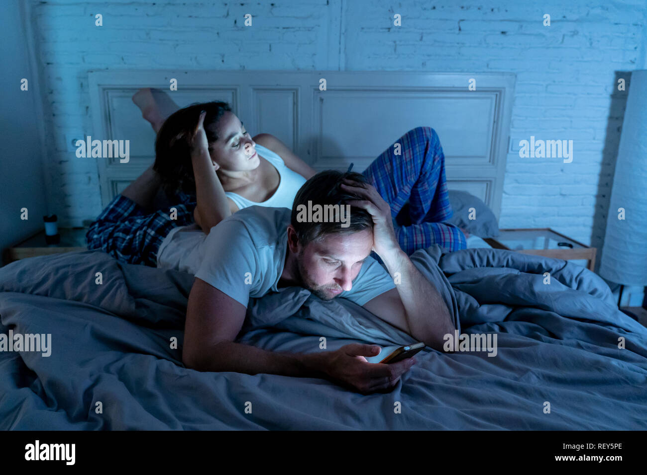 Traurige Mann und Frau Ehepaar mit Ihren smart Handy nachts im Bett  gegenseitig ignorieren als Fremde in Beziehung und Kommunikation pro  Stockfotografie - Alamy