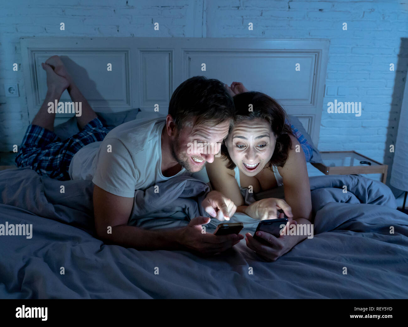 Lächelnd attraktive junge Männer und Frau Paar mit Smartphone auf dem Bett zusammen liegen. Gerne Freund und Freundin Kontrolle soziale Netzwerke oder mobil Stockfoto Lächelnd attraktive junge Männer und Frau Paar mit Smartphone auf dem Bett zusammen liegen. Gerne Freund und Freundin Kontrolle soziale Netzwerke oder mobil Stockfoto