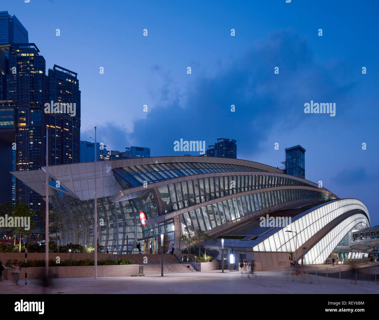 Insgesamt Seitenansicht in der Abenddämmerung. West Bahnhof Kowloon, Hong Kong, China. Architekt: Andrew Bromberg Aedas, 2018. Stockfoto